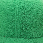 Chapeau-fourré-vert-style-doux-à-côté-de-livre