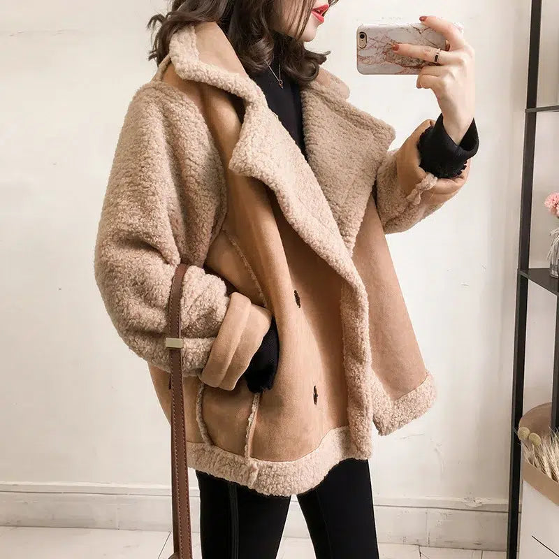 Femme-portant-un-blazer-moumoute-beige-duveteux-devant-un-miroir